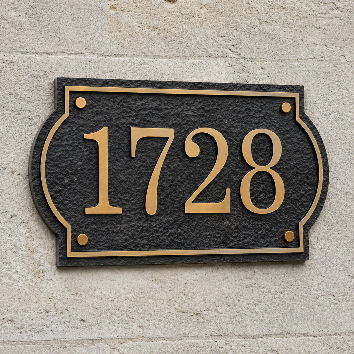 Custom aluminum house number 1728 mounted on a light masonry wall