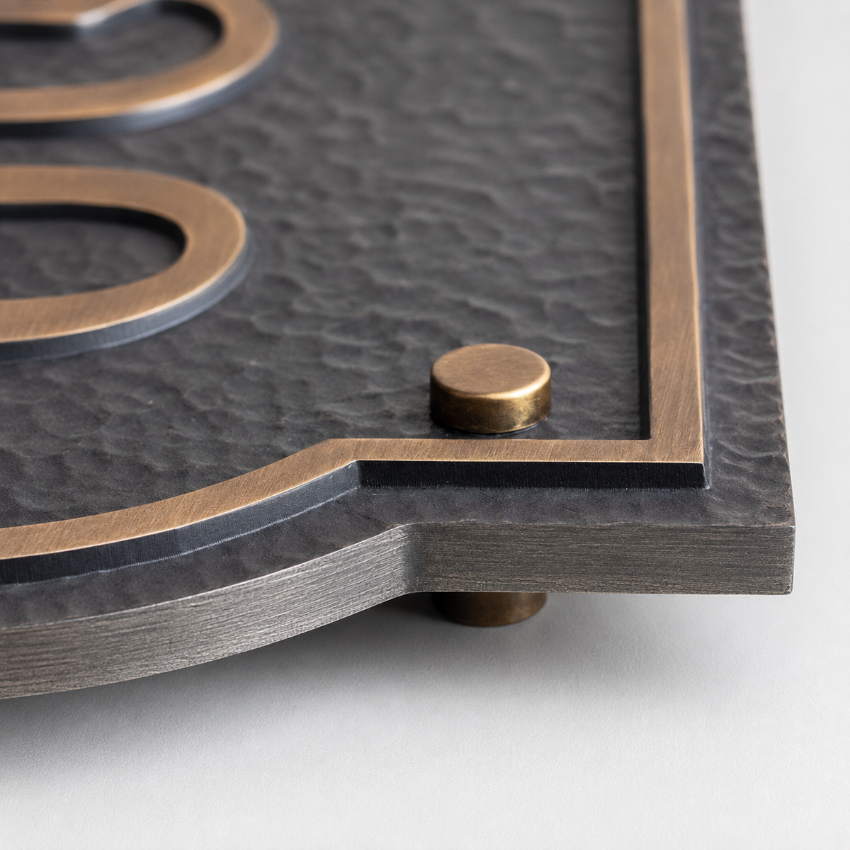 Close-up of antique brass border and decorative standoff on solid aluminum plaque